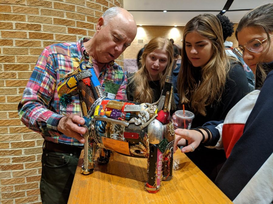 Artist Leo Sewell shows one of his pieces to the art students. 