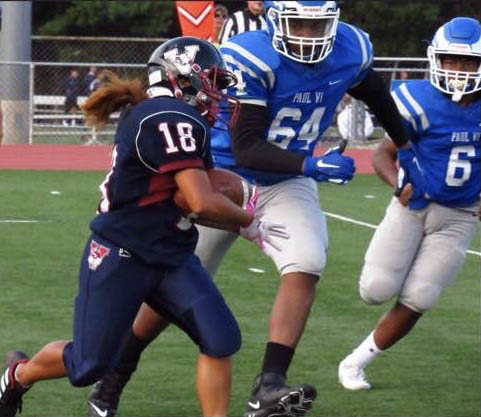 Jasmeen Duque '22 rushes the football down field, evading Paul VI defenders.