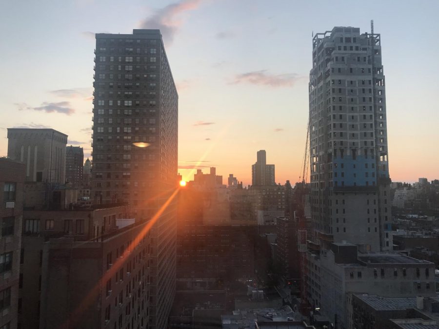 The sun sets over the view from behind the window on the 21st floor of an East 80s building in New York City. 