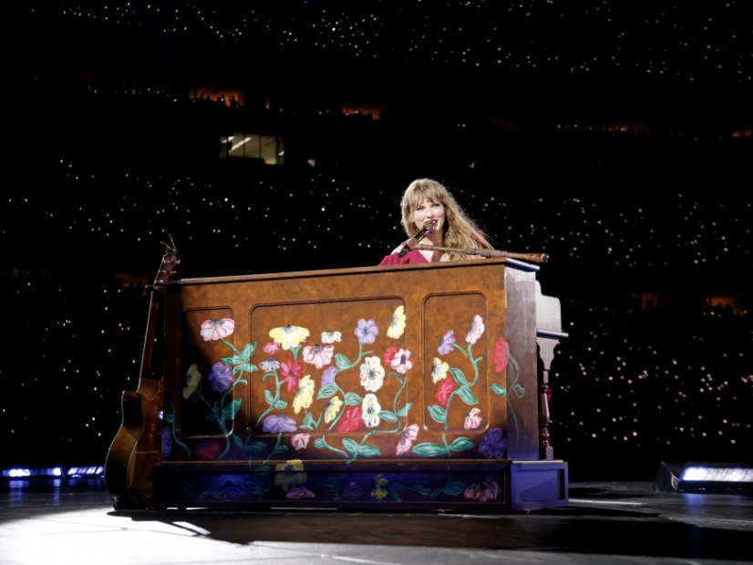 Swift sitting at the iconic surprise song piano. 